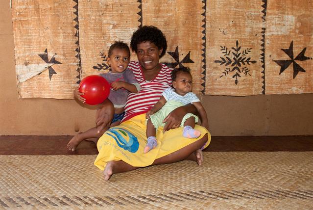 Tania und ihre zwei Kinder Seveci und Laitea. Im Hintergrund ist ein Wandbehang, welcher aus bearbeiteter Baumrinde besteht und bemahlt wurde. Leider haben wir bei diesem Besuch beiläufig gesagt, dass er uns gefällt. Dies heisst auf Fijianisch "Ich hätte ihn gerne". Und so ist er ungewollt in unseren Besitz gekommen. Eine Rückgabe ist unmöglich.